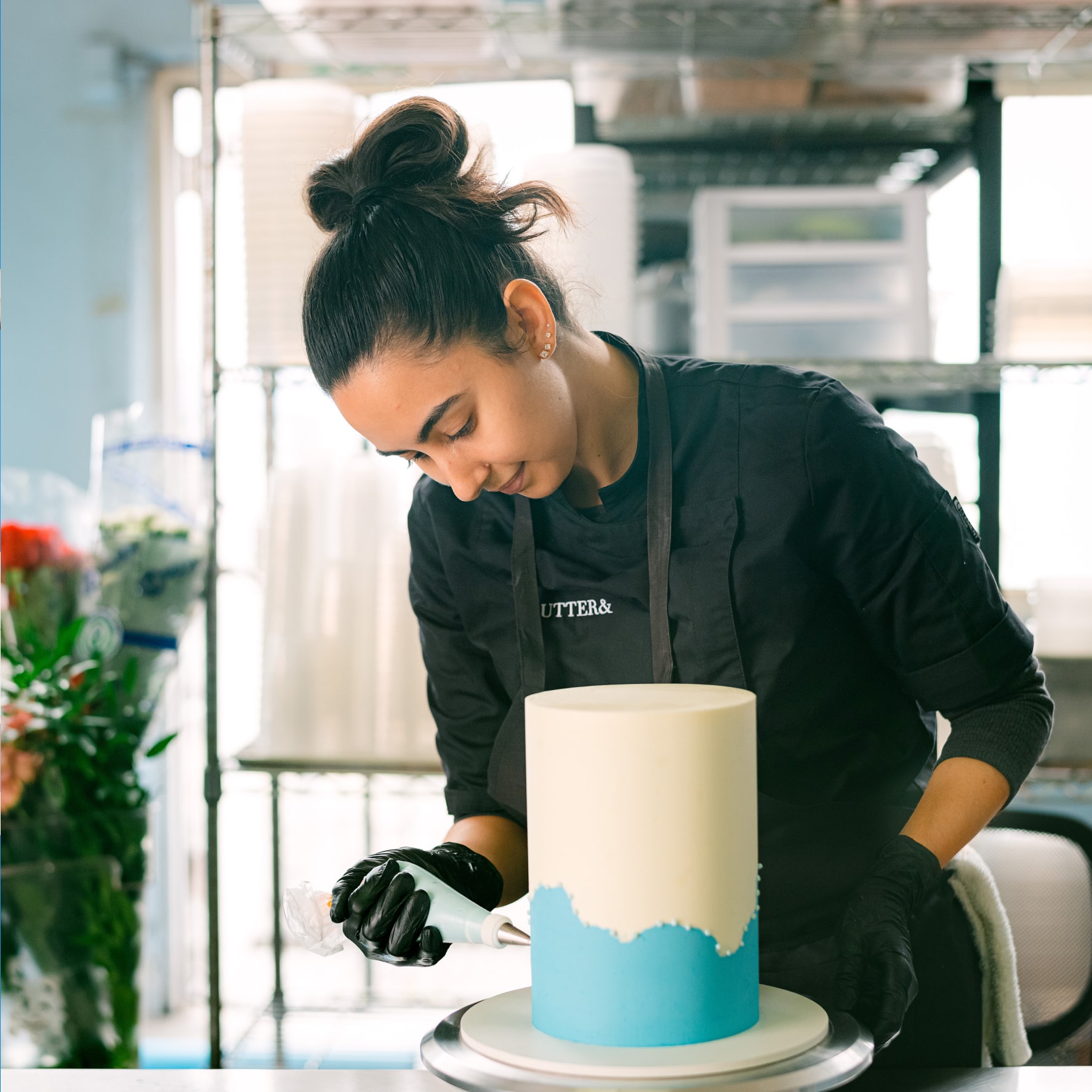 A Xero user decorating a cake with blue icing. Social proof badges surrounding the circular image.